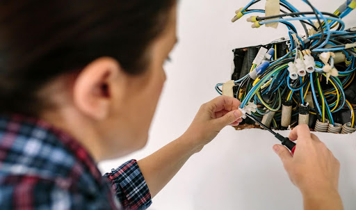 Mujer realizando instalación de redes eléctricas